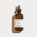 An amber glass spray bottle labeled 'MESA' by Lost Canyon, a water-based, skin-safe room and linen spray with notes of cardamom, teak, and yucca flower. 